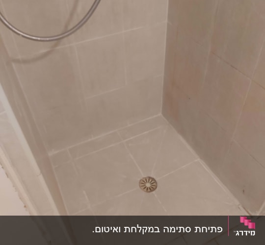 מקלחת עם ראש מקלחת וניקוז ברצפה